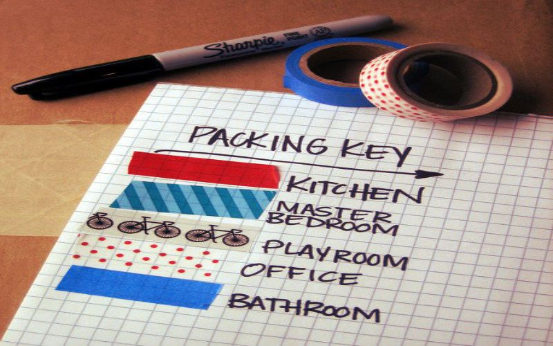 happy couple sitting on a couch with some cardboard boxes around them