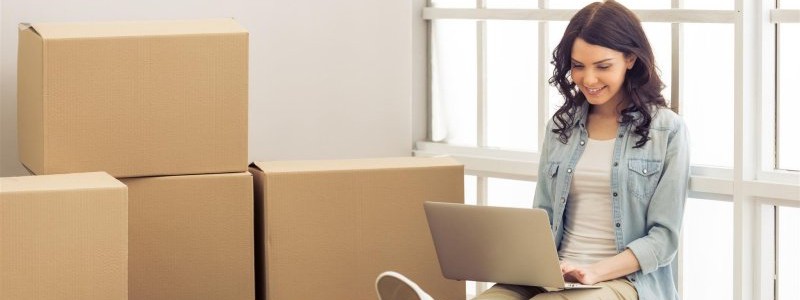 young woman with a laptop preparing for a relocation