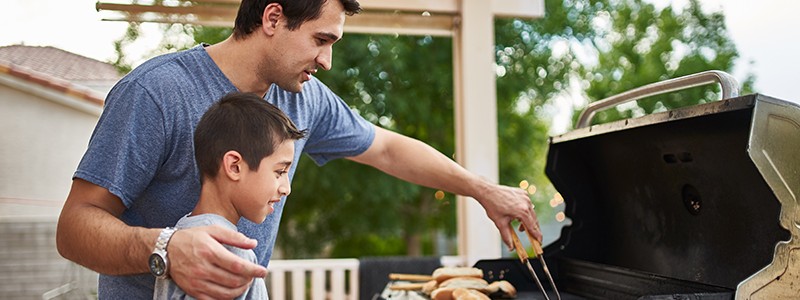 young father is grilling food with his son