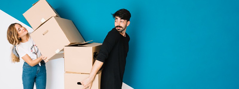 young couple holding cardboard boxes preparing for a relocation