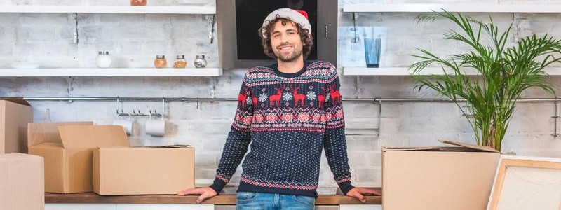 young man wearing christmas cap preparing for a standing inside of a house