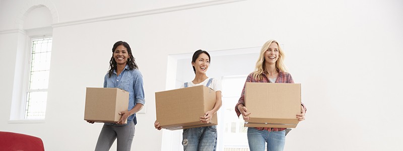 group of friends with cardboard boxes into their new rental