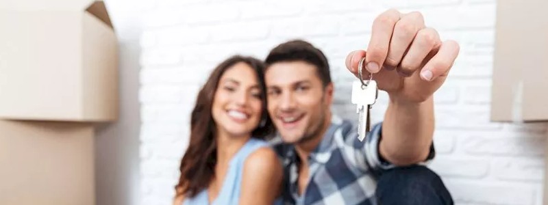 happy couple showing the keys of their new house
