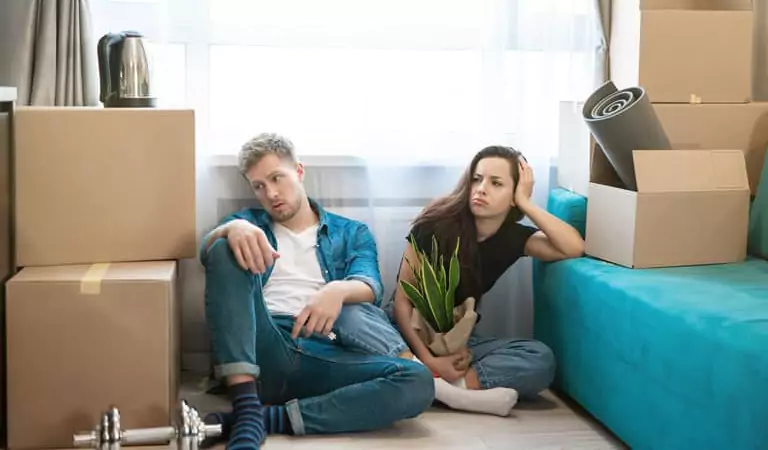 couple looking worried and sitting on the floor