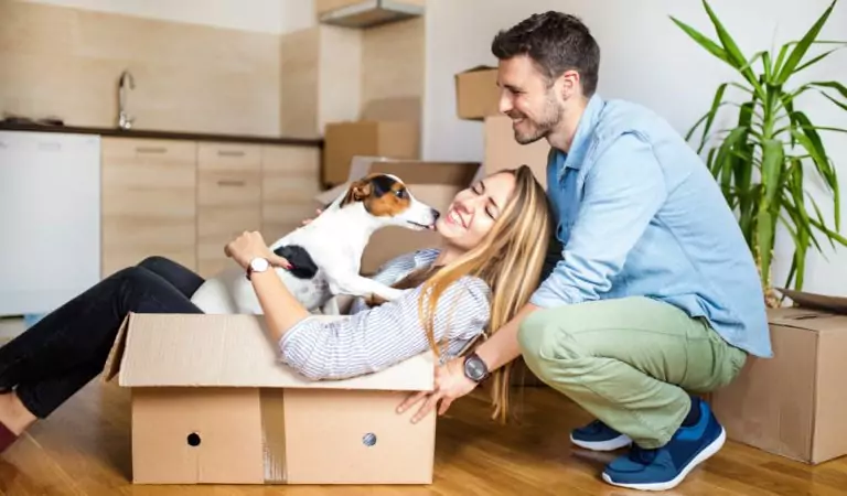 couple inside of their new house playing with their pet