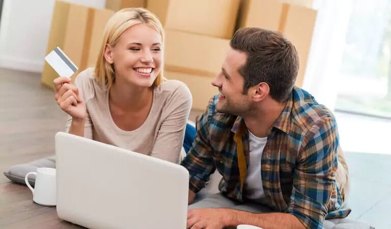 couple purchasing something online and some cardboard boxes in the back