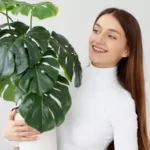 woman with a plant inside of their new house
