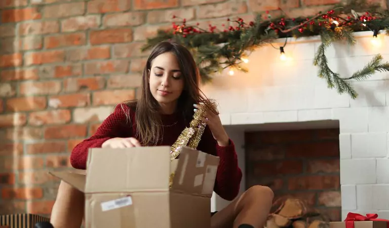 woman packing up a box while sitting on the floor