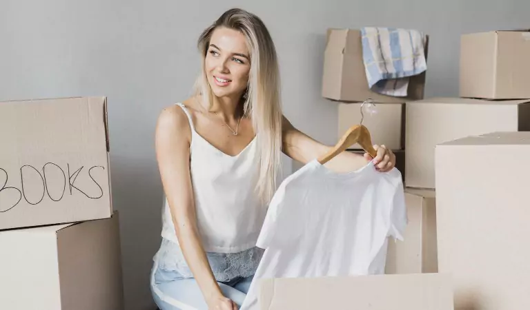 young woman packing her clothes for a move