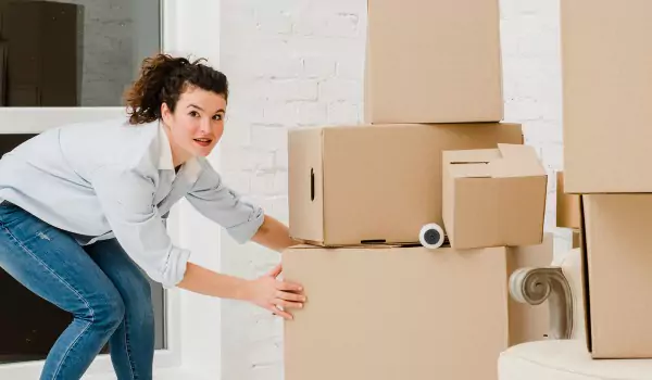 woman trying to lift cardboard boxes