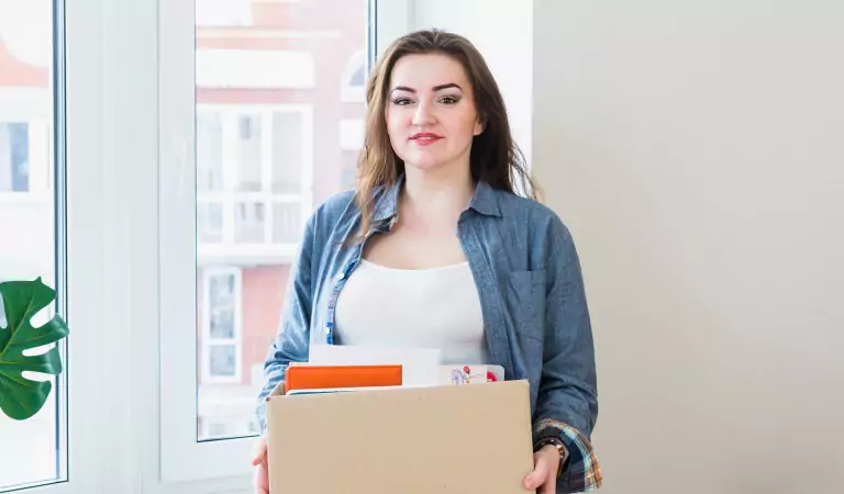 woman with a cardboard box during the office moving process