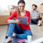 Young couple with digital tablet resting in their new home