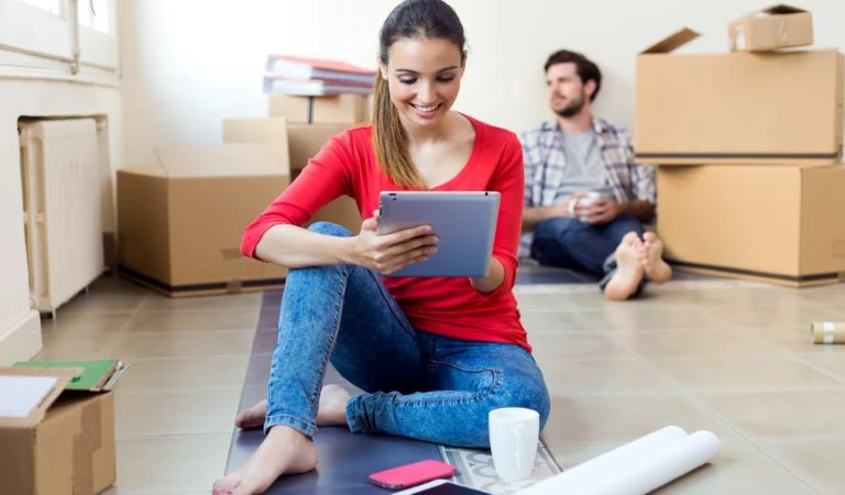 Young couple with digital tablet resting in their new home