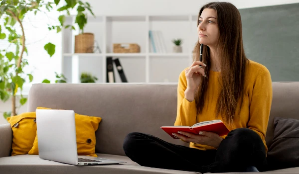 Full shot woman on couch thinking
